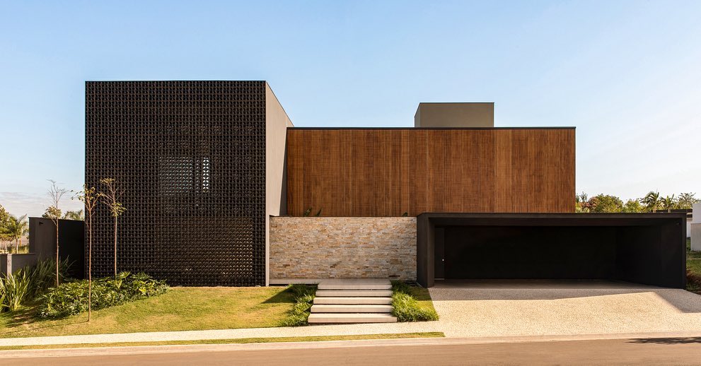 Arquitectos usan ladrillos de cobogó negro y brisas de madera en casas de Brasil